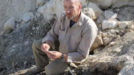 A person doing fieldwork holding an object 